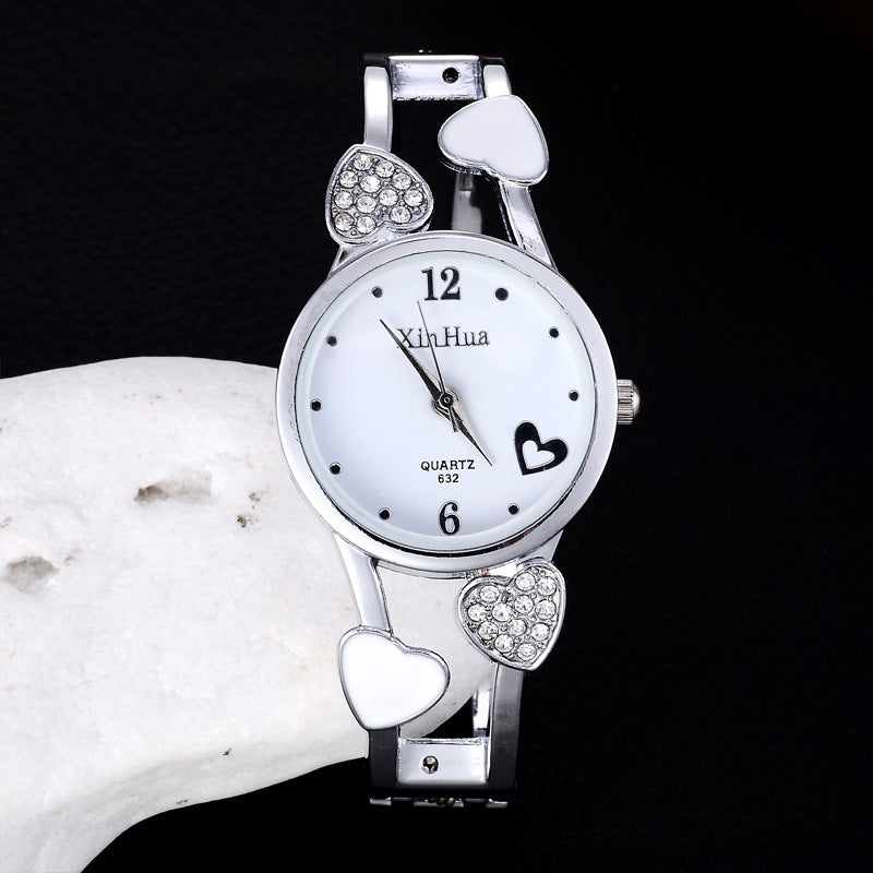 Britique women's diamond-set quartz watch with white dial, heart accents, and stainless steel pin buckle.